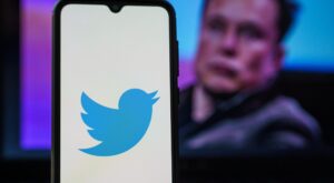 elon musk mit smartphone und twitter symbol