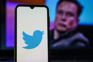 elon musk mit smartphone und twitter symbol